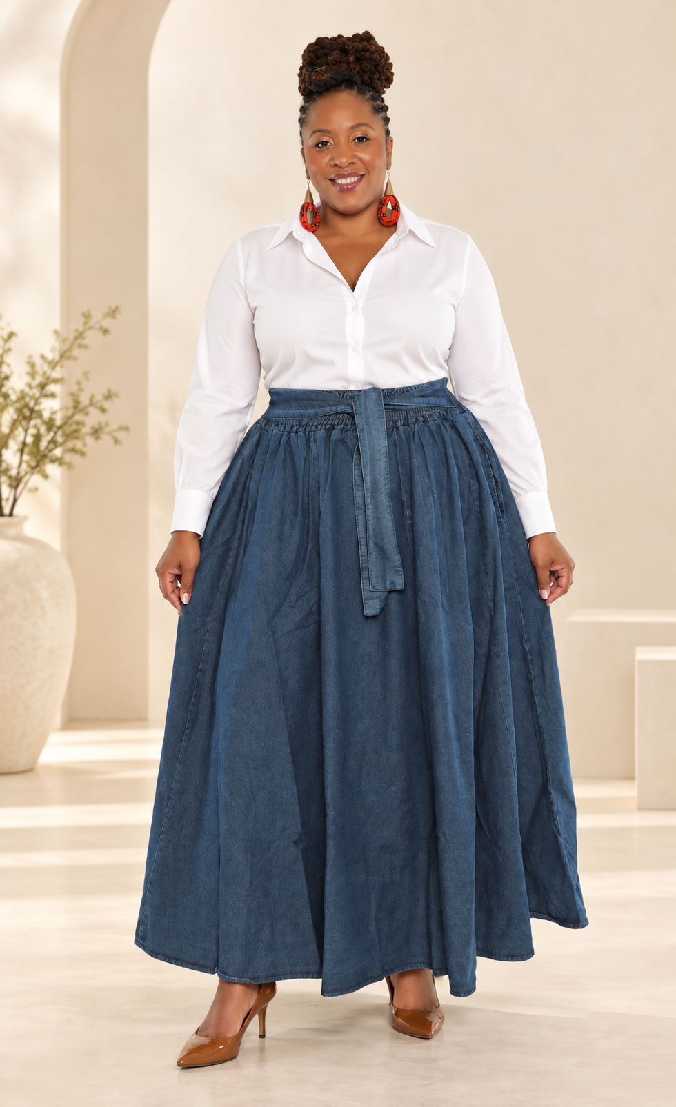 African American woman wearing a full belted denim maxi skirt styled with a white button-up shirt